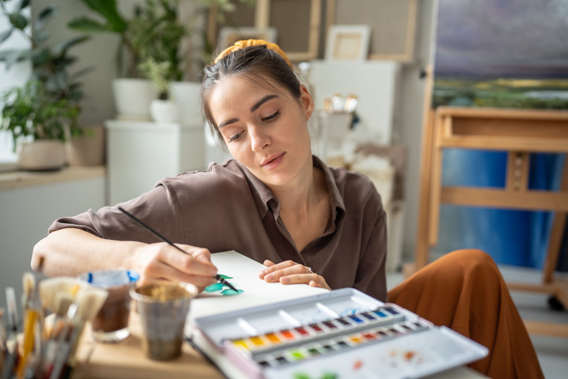 Thoughtful female artist painting with watercolor. Creative painter at home art creative workshop