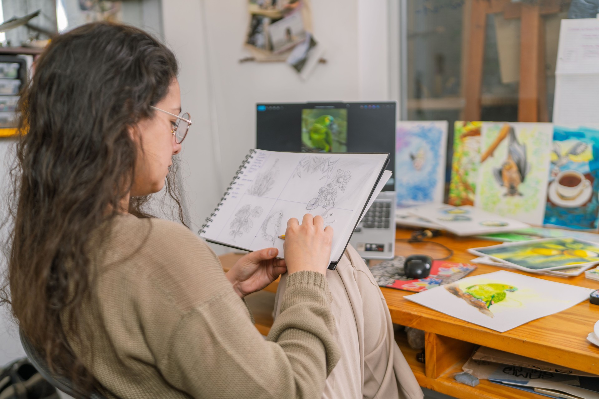 Graphic designer sketching in her home studio: using pencil and notebook